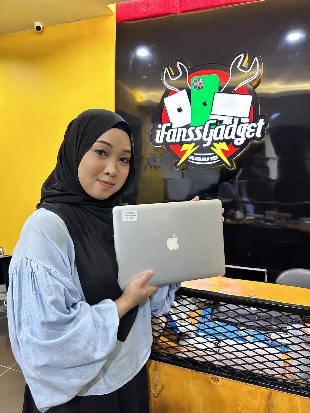 Pelanggan bersama MacBook di kaunter di iFanss Gadget