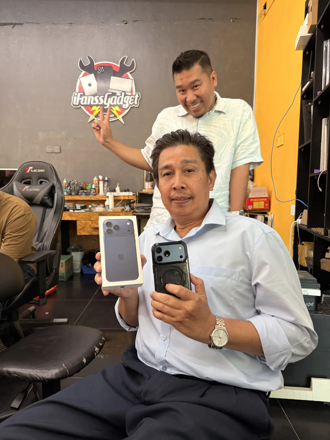 Pelanggan menunjukkan iPhone di iFanss Gadget